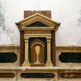 ...e un tabernacolo timpanato raffigurante un calice su sfondo rosso e nero